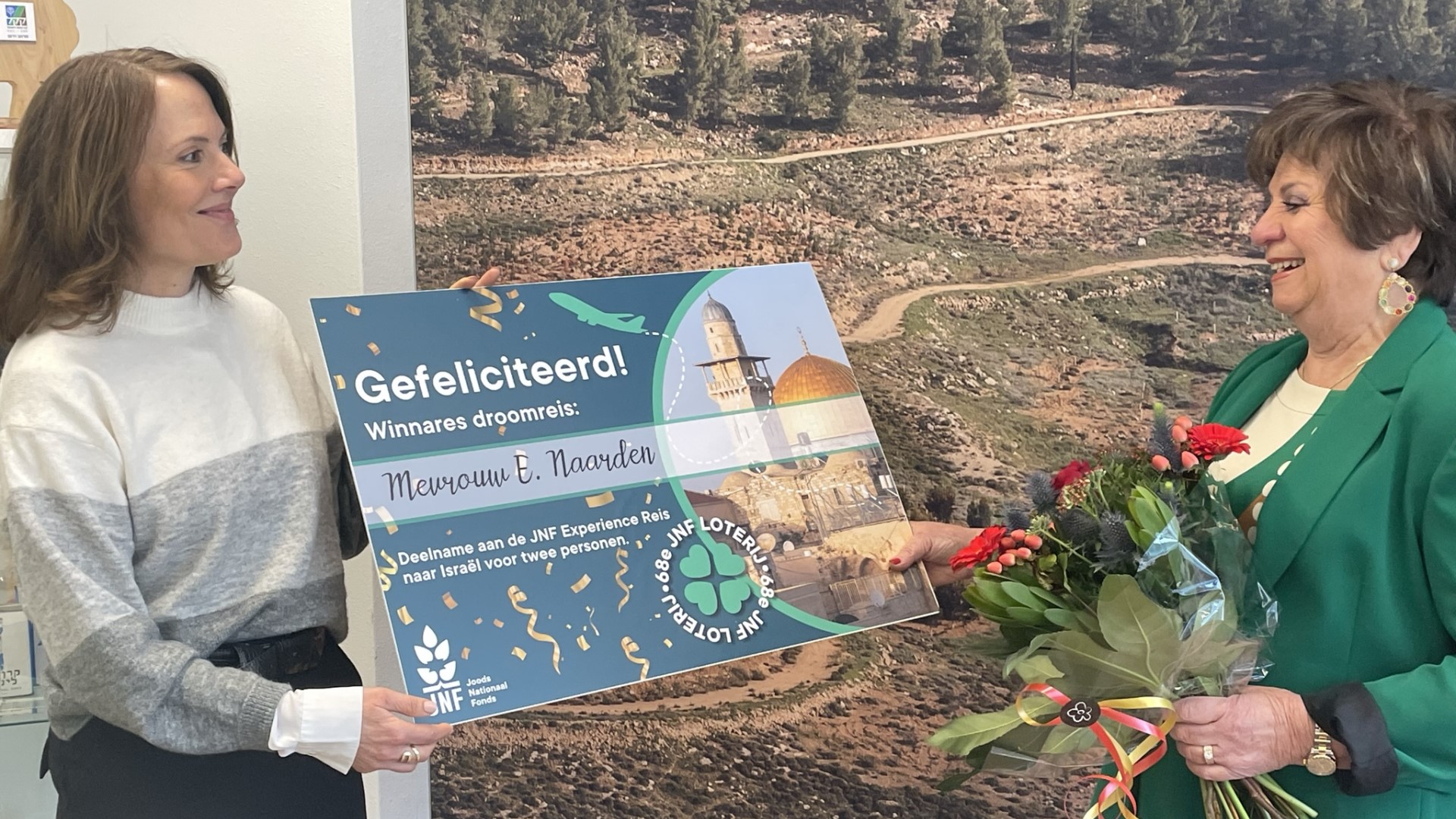 Hoofdprijs winnaar Elly Naarden ontvangt cheque en bloemen